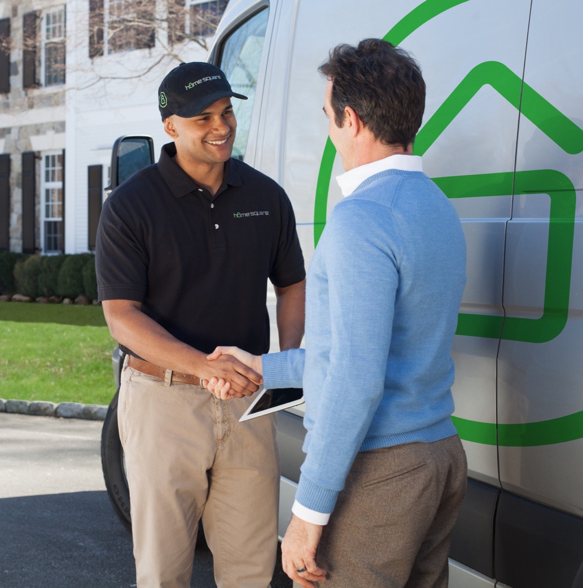 A HomeSquare Pro technician shaking hands with a homeowner beside a branded van